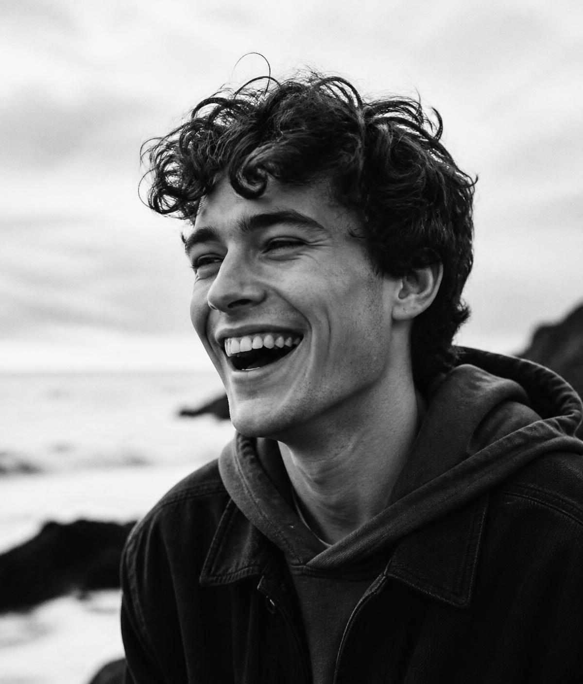 A young man laughing, black and white portrait